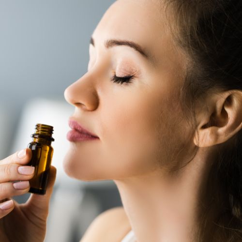 Mujer inhalando un fraso de aceite esencial