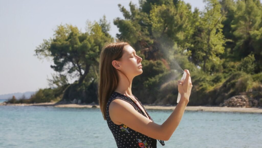 Mujer aplicándose hidrolato de lavanda tras exposición al sol en la playa