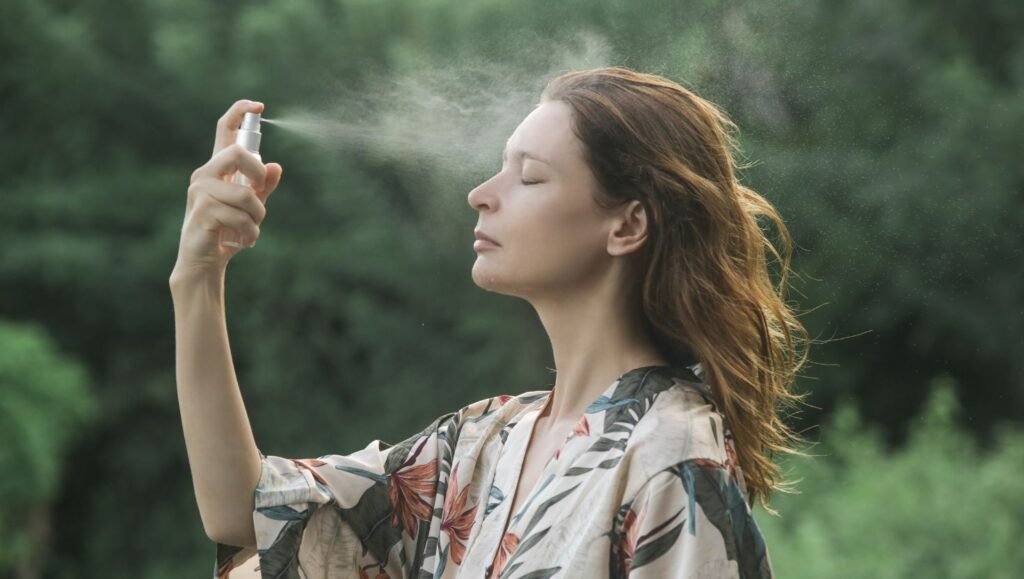 Mujer aplicándose hidrolato en la cara